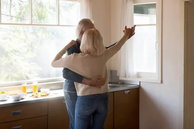 whitehaired couple dancing in kitchen 